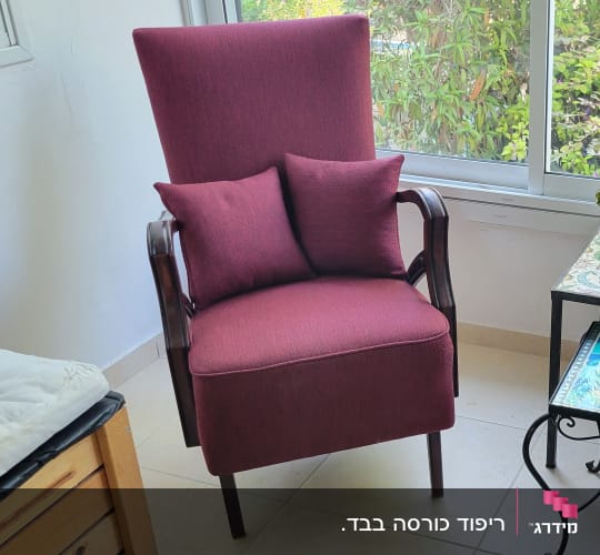 כורסה מרופדת בבד אדום עם כריות תואמות